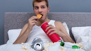 Man enjoying chips while watching television