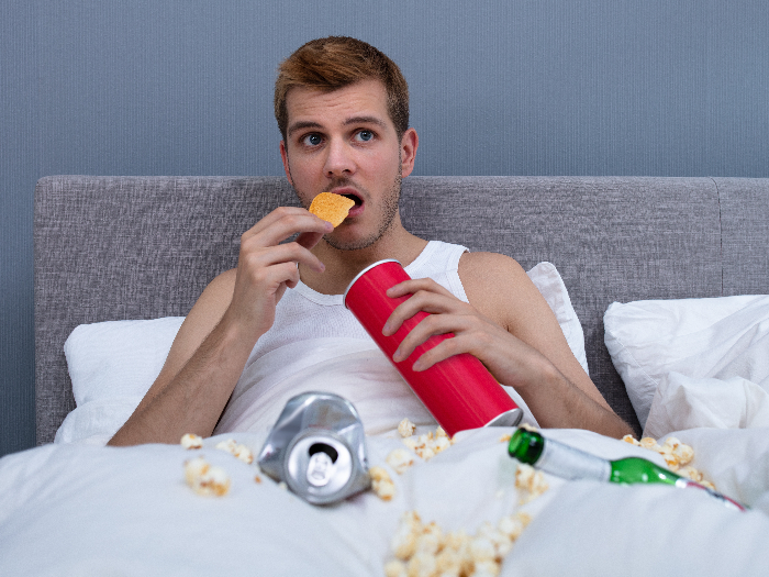 Man enjoying chips while watching television