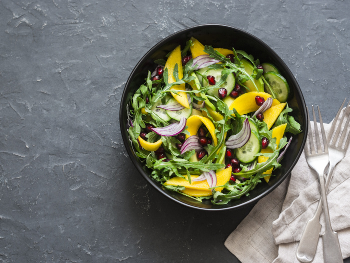 Tropical mango, avocado, cucumber, arugula salad on a plate