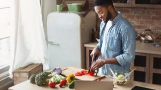 A man preparing vegetable salad in loft kitchen