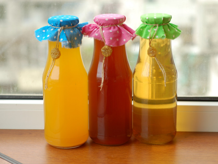 Different varieties of mead in glass bottles with colorful cloth lids