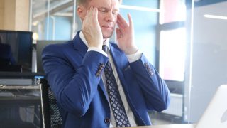 A stressed businessman sitting in his cabin