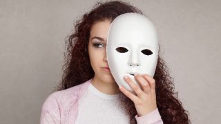 Sad girl hiding her real emotions behind a mask