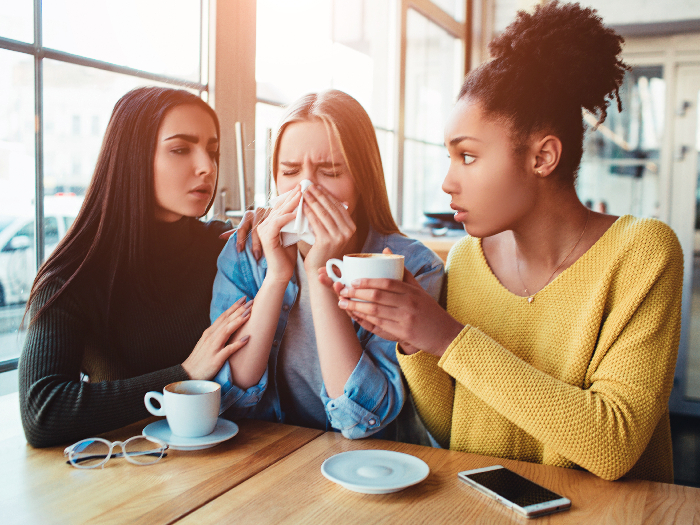 Two friends trying to console another friend who is heartbroken