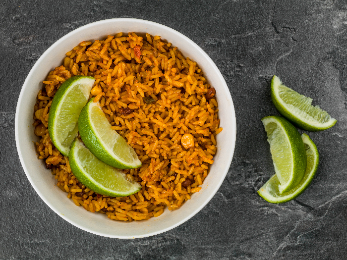 Bowl of Spicy Mexican Rice With Fresh Lime Against a Black Slate Tile Background