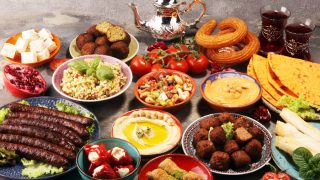 Middle eastern or arabic dishes and assorted meze, concrete rustic background. Falafel. Turkish Dessert Baklava with pistachio. Meat kebab, falafel, baba ghanoush, muhammara, hummus, tahini, kibbeh