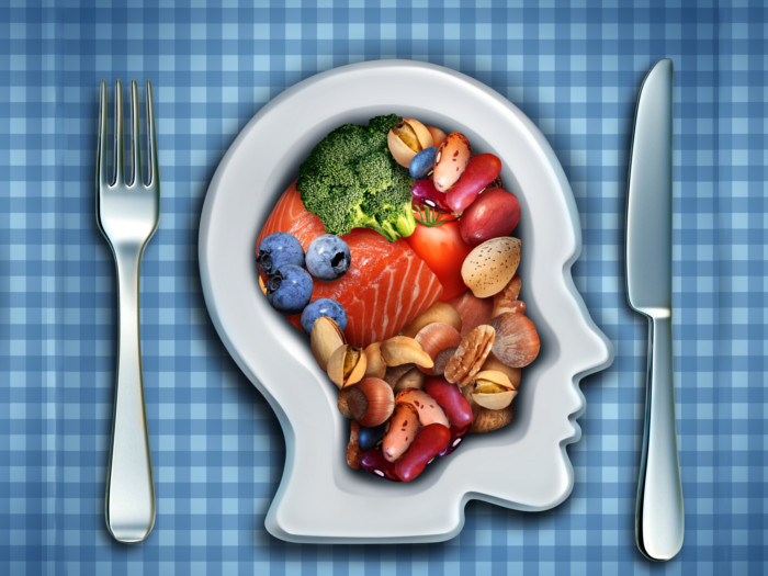 A plate resembling a head filled with food and a fork and spoon on either side of it