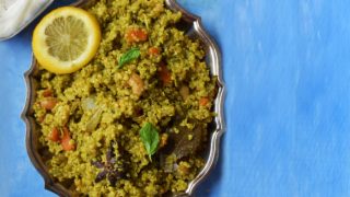 Mint quinoa atop a blue table beside a bowl of curd
