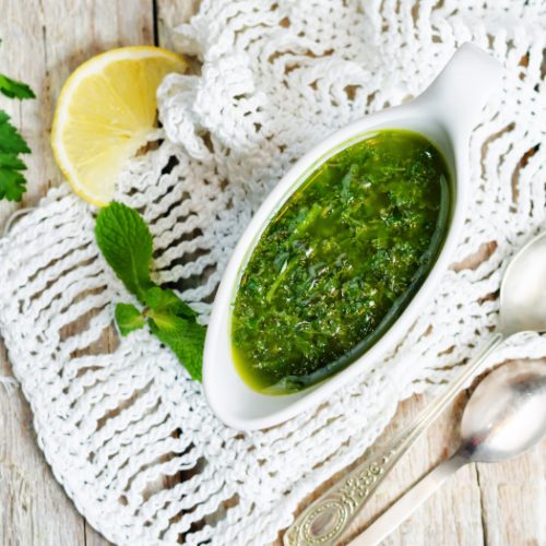 A flatlay picture of mint parsley green sauce on a wood table