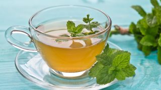 A close up shot of mint tea kept atop a blue platform