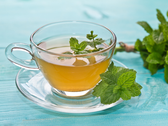 A close up shot of mint tea kept atop a blue platform