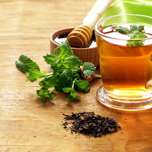 Mint flavoured tea in a glass cup on a wooden table