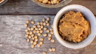 Miso paste in a bowl surrounded by grains