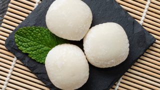 Japanese mochi ice cream with mint leaves on the wooden mat