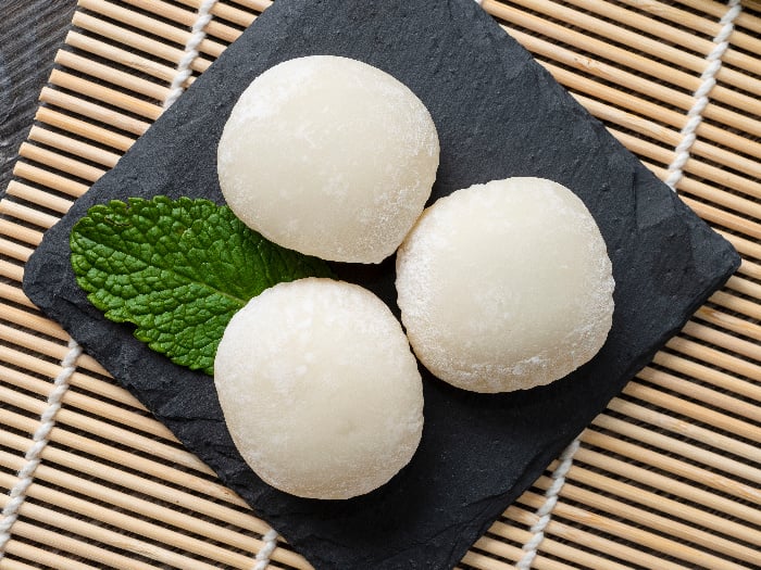 Japanese mochi ice cream with mint leaves on the wooden mat