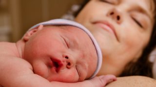 A close-up shot of a mother and baby sleeping