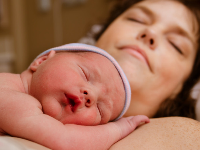 A close-up shot of a mother and baby sleeping