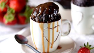 Delicious chocolate cake cooked in a microwave in a mug with caramel syrup