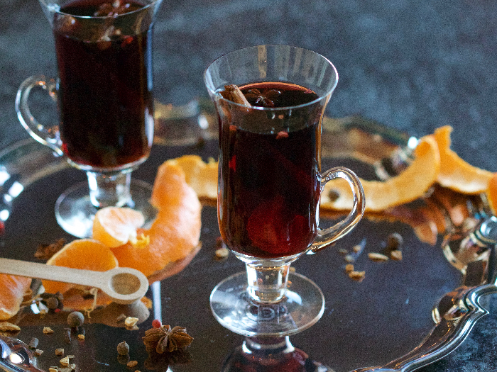 A close up shot of mulled wine in two glasses kept atop a silver tray