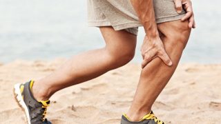 A man with muscle cramp on his right leg who was running on the sand