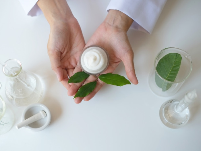 A bowl full of white cream being displayed in two hands