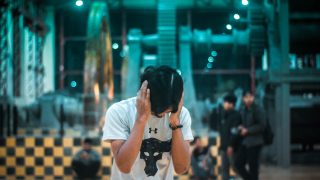Man closing his ear with machines in the background
