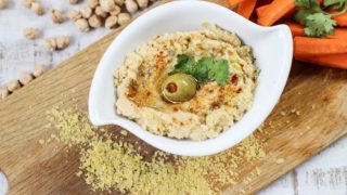 A bowl of nutritional yeast served with olive and cilantro