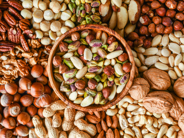 Different kinds of nuts with a bowl in the centre filled with nuts