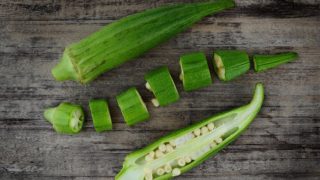 Fresh and sliced okra or lady finger on a wooden table