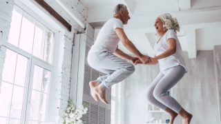 Older couple jumping on the bed