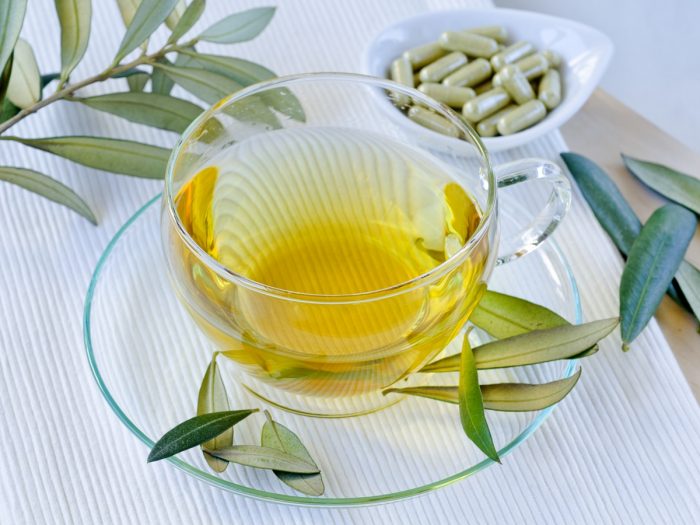 A close up shot of olive leaf tea, kept atop a white platform