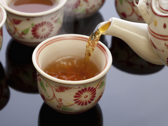 Tea is poured from a teapot into a cup