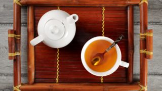 Top view of a tray containing a teapot and a cup of tea