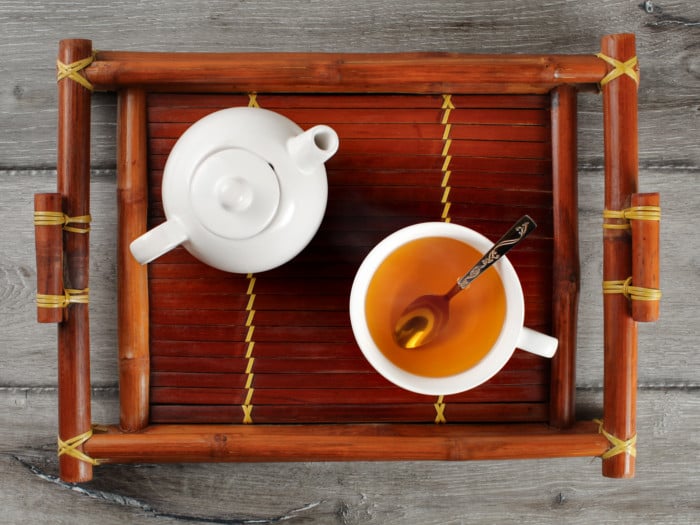 Top view of a tray containing a teapot and a cup of tea