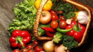 Upturned basket of vegetables on a rustic surface