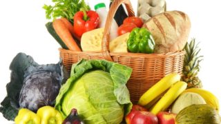 A huge basket of fresh organic vegetables on a wooden table
