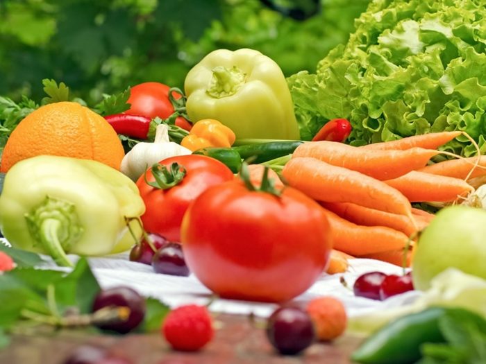 Fresh vegetables and salad leaves on a wooden counter