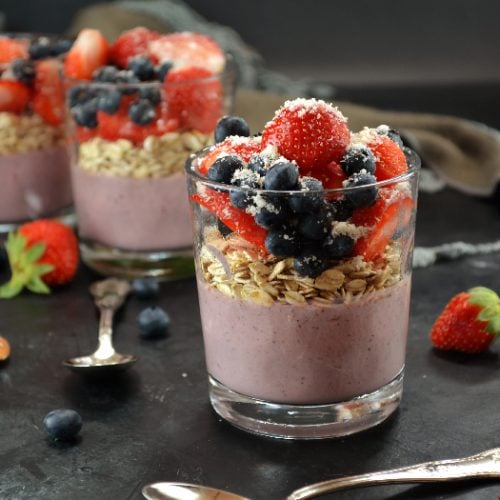 Overnight oats with acai powder, topped with berries and coconut flakes