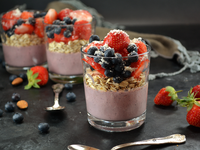 Overnight oats with acai powder, topped with berries and coconut flakes