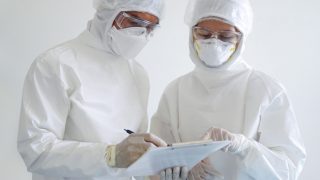 Doctor and nurse wearing PPE, checking reports