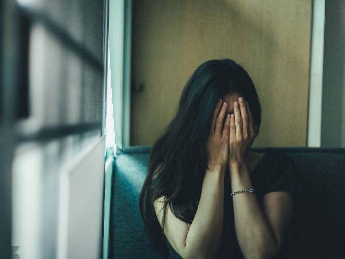 Woman covering her face with her hands