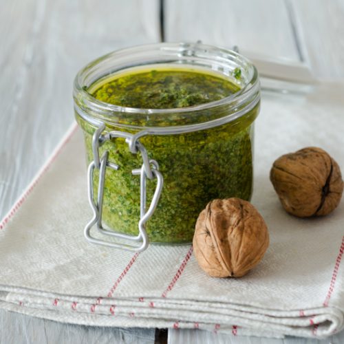 Walnut parsley pesto in a jar on a white background