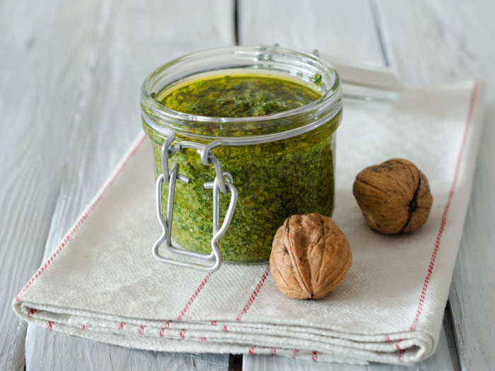 Walnut parsley pesto in a jar on a white background