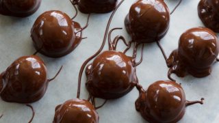 Chocolate peanut butter balls on wax paper