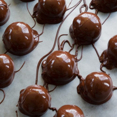 Chocolate peanut butter balls on wax paper