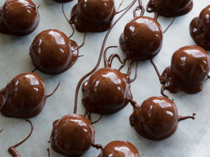 Chocolate peanut butter balls on wax paper