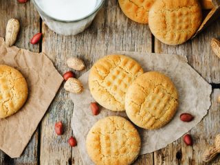 peanutbuttercookieone Peanut butter cookies on butter paper with fresh peanut lying around them