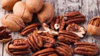 Pecan nuts and pecan shells on a wooden table
