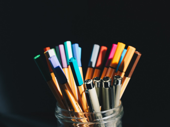 Colorful pens in a pen jar or stand with black background