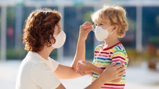 Mother helping her child fix the facemask